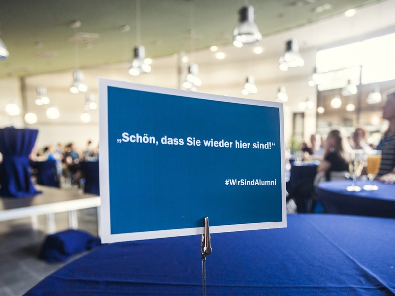Alumni-Veranstaltung mit Willkommensschild.