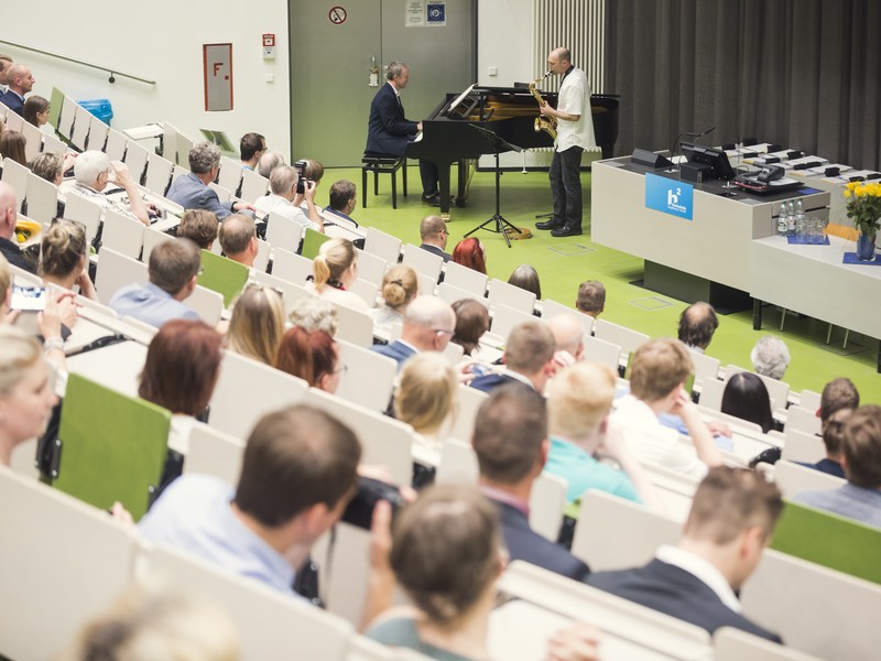Absolvent:innen im Hörsaal bei einer Absolvent:innenfeier.