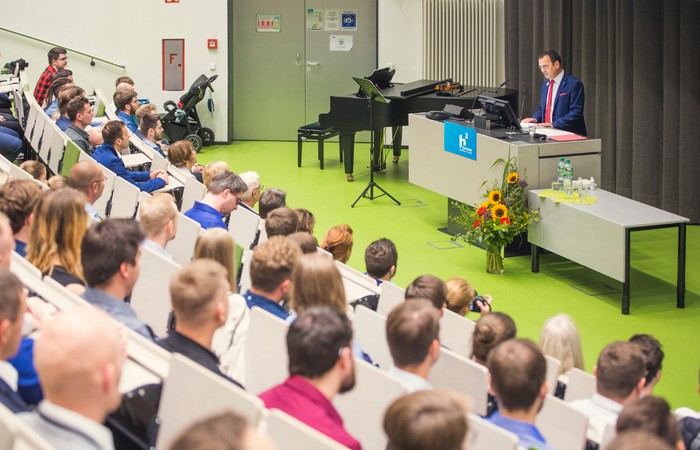 Absolvent:innen und Lehrende im Hörsaal bei einer Absolvent:innenfeier.