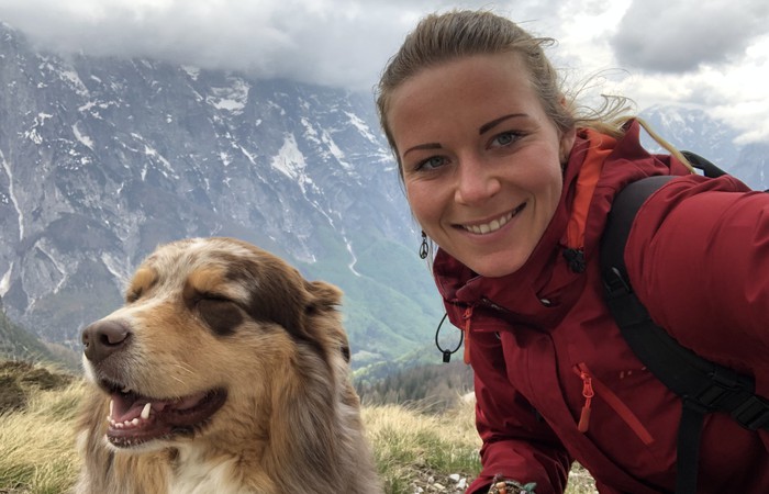 Foto der Absolvent:in Maren Huhle mit ihrem Hund in den Bergen.