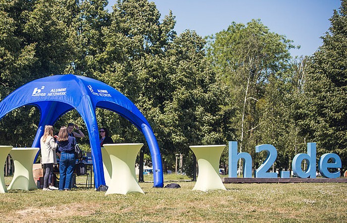 Alumni-Stand auf dem Campus neben dem "h2.de-Schild".
