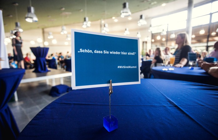Alumni-Veranstaltung mit Willkommensschild.