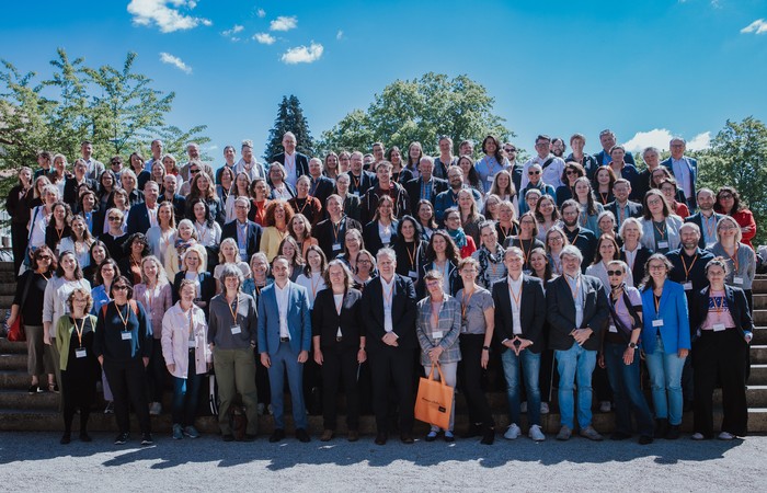 Gruppenfoto der Teilnehmenden des Netzwerktreffens und er Mitgliederversammlung auf einer Treppe.