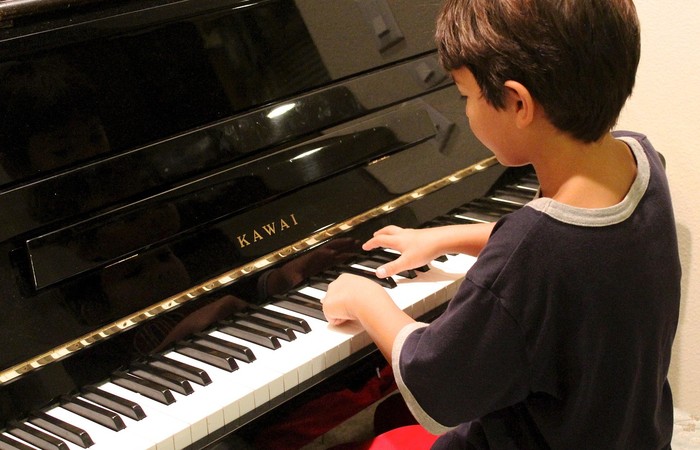 Junges Kind spielt Klavier.