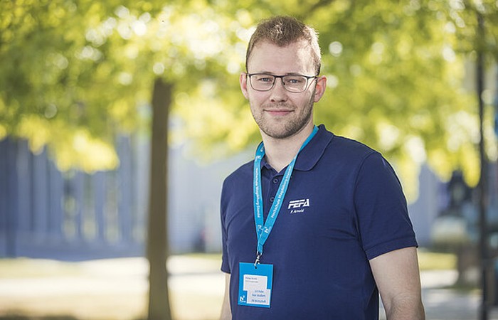 Foto von Absolvent Philipp Arnold auf dem Campus.