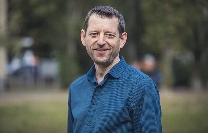 Foto von Absolvent und Mitarbeiter Markus Lippmann auf dem Campus.