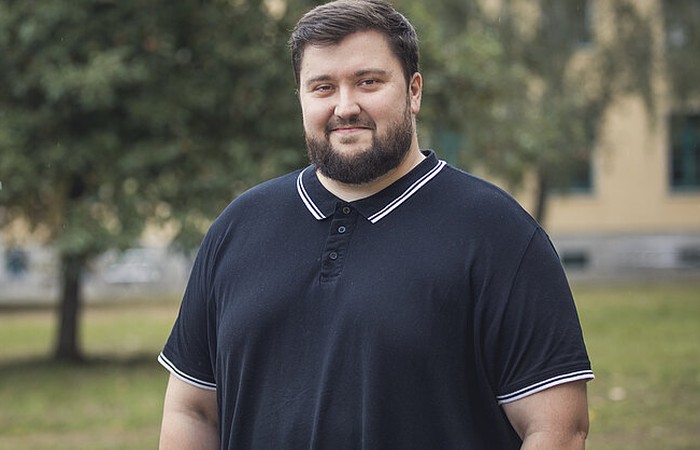 Foto des Absolventen und wissenschaftlichen Mitarbeiters Daniel Menschulin auf dem Hochschulcampus.