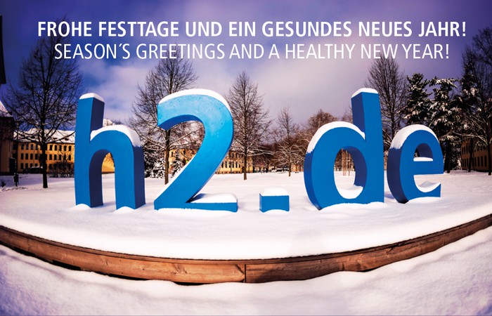 Frohe Festtagsgrüße mit verschneitem h2-Logo.