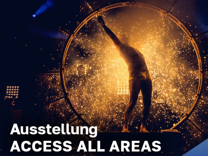 Foto eines Künstlers in einem runden Holzrad und Lichteffekten.