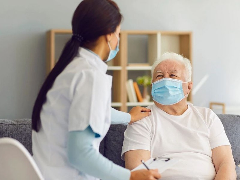 Medizinische Fachkraft im Gespräch mit einem Patienten.