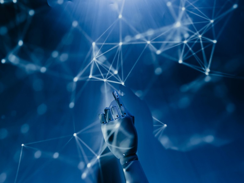 Mechanischer Arm berührt digitales Netzwerk.