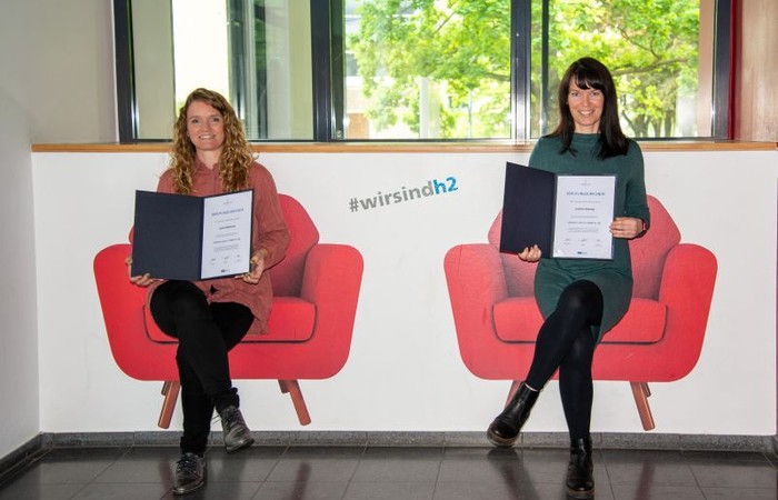 Foto von Sarah Hildebrand und Josefine Winning im Wandsitz im Hörsaalzentrum.